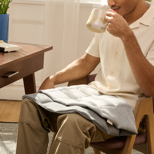 Using the weighted lap pad while seated in a chair